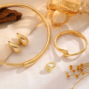 Detail of 18K gold-plated jewelry set with water drop earrings and chunky necklace
