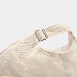 Detail showing adjustable metal buckle and stitching on cream cotton baseball cap
