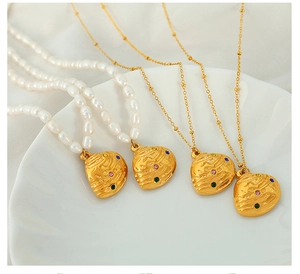 Detailed macro view of four heart pendant necklaces with colorful zircons on shell tray