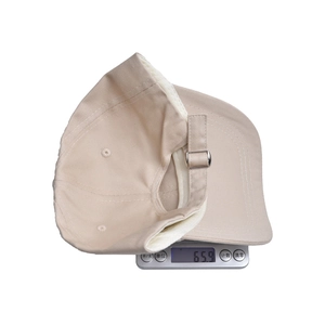 Beige cotton baseball cap with excavator embroidery weighing 65.9g on a scale
