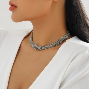 Detail of layered silver punk choker necklace with metallic braided chains on model