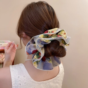 Macro detail of a large floral chiffon scrunchie with colorful oil painting pattern