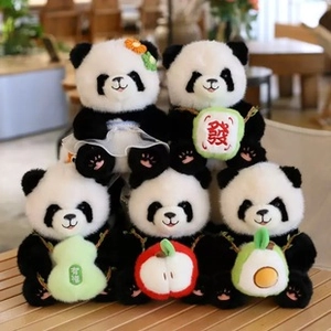 Close-up of cute panda plushies with floral dress and lucky charms on a wooden table