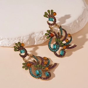 Detail of vintage gold earrings with colorful rhinestones on a textured stone base