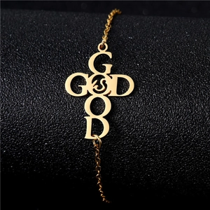 Gold stainless steel bracelet with cutout Good God cross pendant on black background