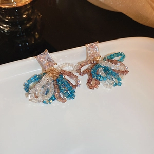 Détail de boucles d'oreilles fleur avec cristal carré et franges de perles colorées