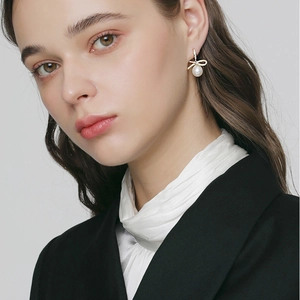 Elegant bowknot pearl earrings with micro-inlaid diamonds on a female model