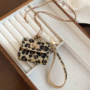Detail of leopard print leather mini pouch pendant with gold twist lock and lanyard