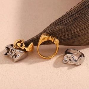 Detailed view of gold and silver heart-shaped embossed stainless steel rings on a natural surface