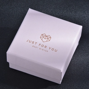 Close-up of square light purple jewelry gift box with gold logo and textured finish