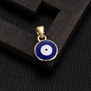 Close-up of golden Evil Eye pendant with blue enamel on a dark wood display stand