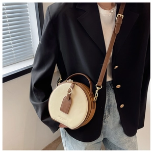 Fashionable round crossbody bag with contrast beige and brown leather texture details