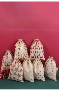 Christmas burlap gift bags with gold foil prints like stars and deer in festive display