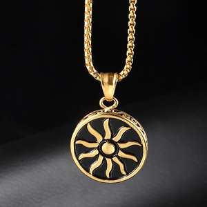Detail of round sun pendant with gold rays and black enamel on a box chain necklace