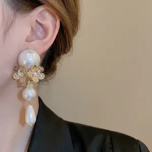 Vintage gold flower earrings with white pearls and tassels for a luxurious statement look