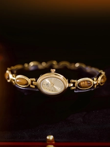 Detailed macro view of vintage gold watch with tiger eye stone and crystal bracelet