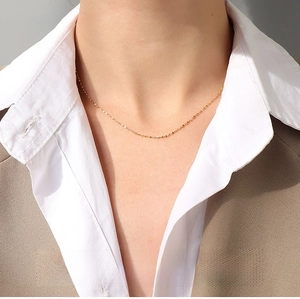 Close-up of 1.1mm gold sparkling star chain necklace in 18K titanium steel on a model