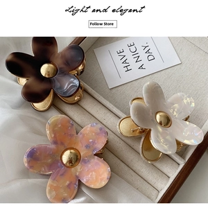 Detailed view of floral acetate hair claws in marble brown pearl white and purple hues