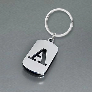 Polished stainless steel keychain with hollow letter A pendant on a minimal gray background