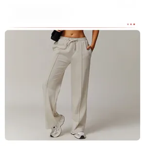Detail of high-waisted loose sweatpants with drawstring and vertical front seams