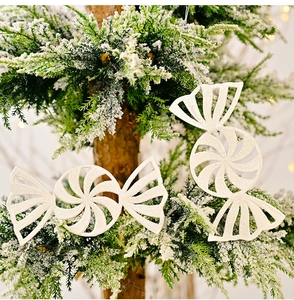 Close-up of white glitter candy cane ornaments with spiral texture on Christmas tree branches