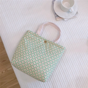 Detail of floral canvas lunch bag with green flower pattern and pink handle strap