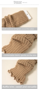 Detail of khaki chunky knit leg warmers showing elastic cuff and lettuce edge hem