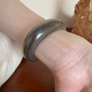 Detail of a gray translucent acrylic bangle with natural textures and elegant finish