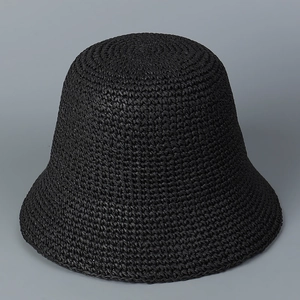 Close-up of black hand-woven straw bucket hat showing refined weaving texture details