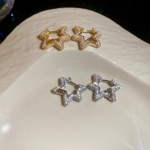 Detailed view of gold and silver hollow star hoop earrings with zircon pavé setting