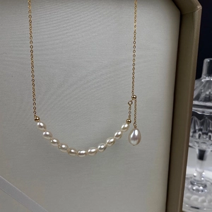 Detail view of natural freshwater pearls and a gold-filled teardrop pendant necklace