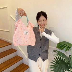 Detailed close-up of a pink embossed rabbit tote bag with floral knit pattern and brand label