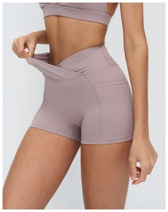 Detail of high-waisted crossover yoga shorts with functional side pockets in mauve