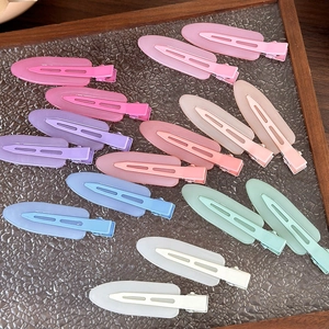 Fermagli per capelli opachi colorati in gelatina disposti su un elegante piatto di vetro