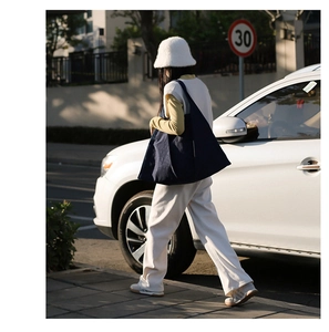 Detail of dark blue geometric tote bag styled with casual white outfit in street view
