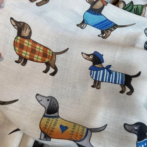 Detail of soft cotton linen scarf showing colorful cartoon dachshund prints and fabric texture