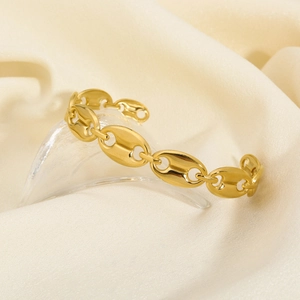 Detailed view of golden coffee bean link cuff bracelet on luxury silk background