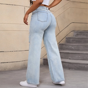 Dettaglio dei jeans a vita alta a gamba larga con strappi e texture denim azzurro