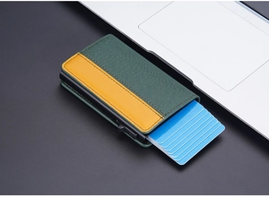 Detail showing the green and yellow textured leather RFID card holder pop-up mechanism