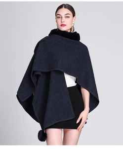 Detail of grey knitted poncho shawl showing luxury faux rabbit fur collar and texture