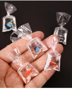 Gros plan de pendentifs créatifs en résine de poissons miniatures dans des sacs d'eau