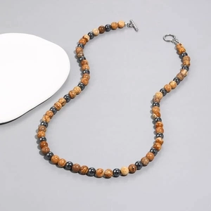 Detail of beaded necklace with brown tiger eye beads and dark grey hematite stones and T-bar clasp