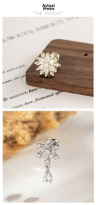 Detailed view of coffee gold snowflake earrings with zircon stones on a rustic wood backdrop