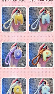 Detail of colorful faux leather alphabet keychains with woven straps and metal rings