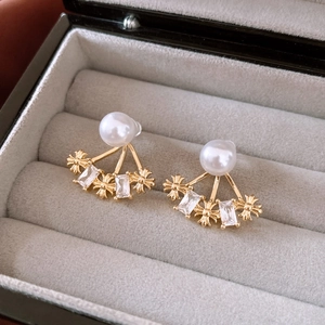 Dettaglio macro di orecchini a fiore placcati oro 14k con perle e zirconi in scatola