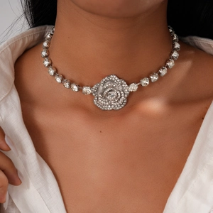 Gros plan du collier pendentif rose argentée avec diamants sur le cou d'un mannequin