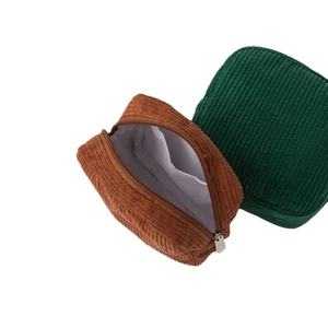Portable corduroy cosmetic bags in brown and green with zipper closure and inner pocket