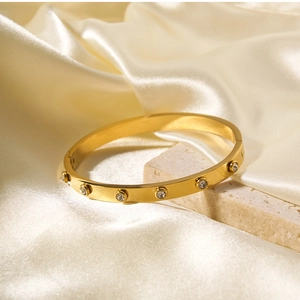 Close-up of 18k gold-plated stainless steel bracelet with cubic zirconia on silk cloth
