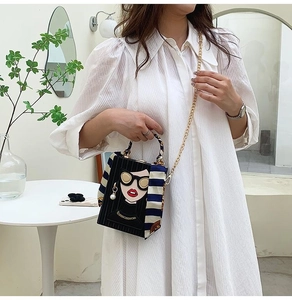 Detail of the elegant graffiti box evening bag with floral scarf handle and gold chain