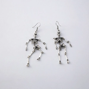 Close-up of vintage silver skeleton earrings with intricate gothic bone textures